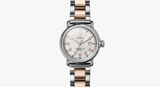 A silver and rose gold watch with a silver case, white dial, and rose gold indices