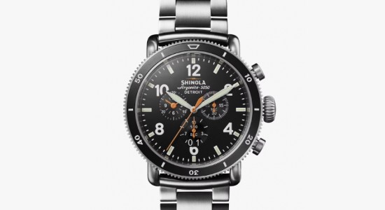 A silver Shinola watch with a black dial, three subdials, and a chronograph complication