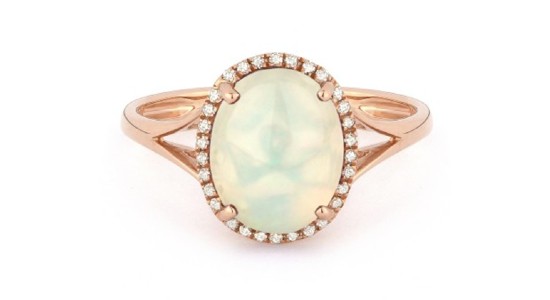 a rose gold statement ring with an oval shaped opal surrounded by diamond accents