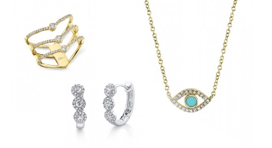 a three tiered, yellow gold fashion ring, a pair of white gold diamond huggies, and a yellow gold eye necklace