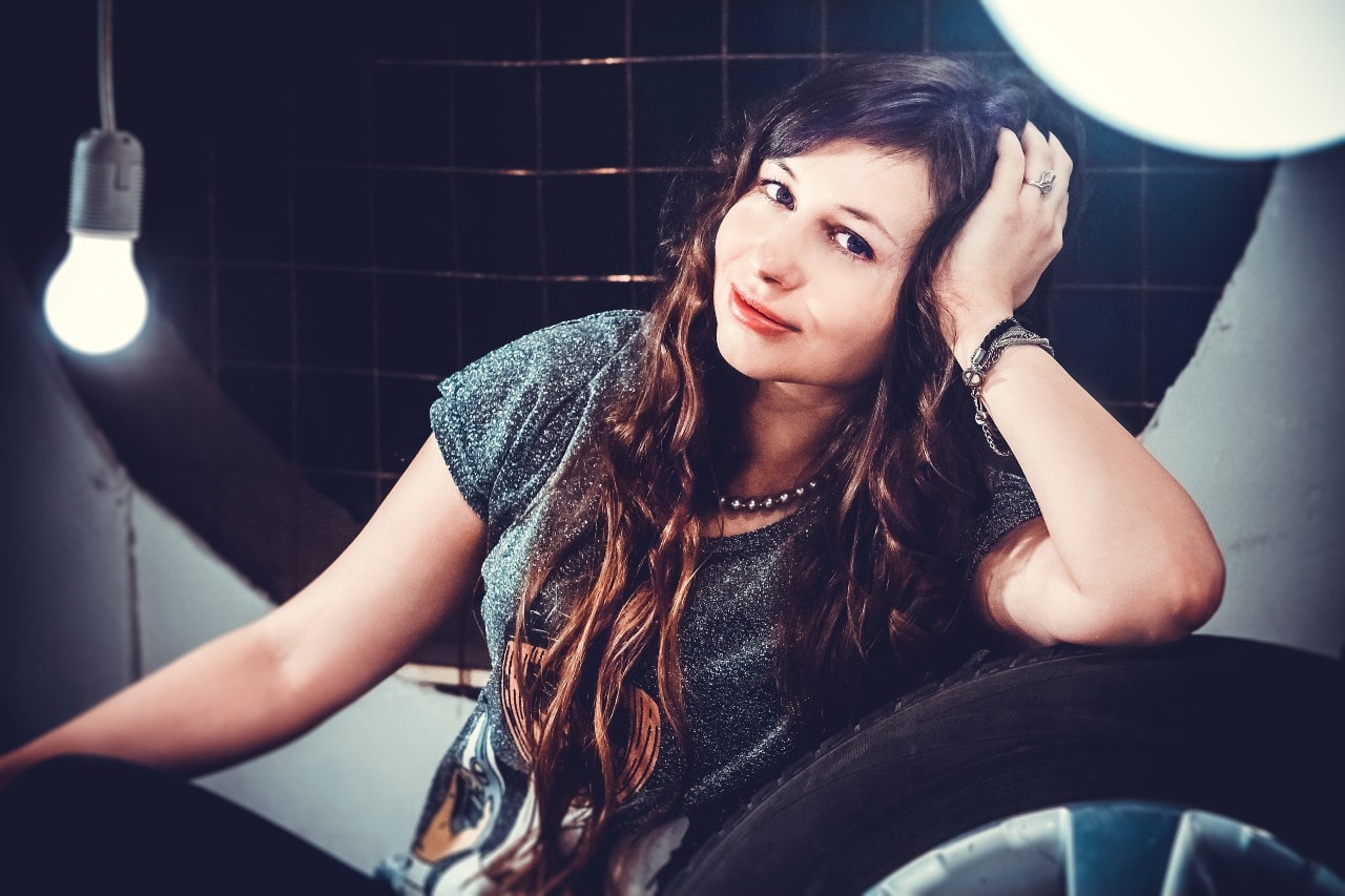 A woman in a tire shop wears a beaded necklace and a variety bracelets. A woman in a tire shop wears a beaded necklace and a variety bracelets.
