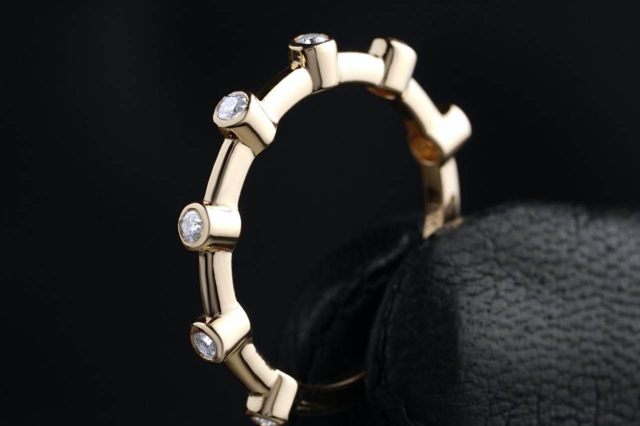 close up image of a gloved hand holding a gold and diamond wedding band close up image of a gloved hand holding a gold and diamond wedding band